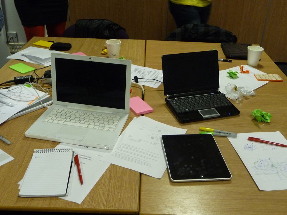A designer arranging printed page layouts on a desk.