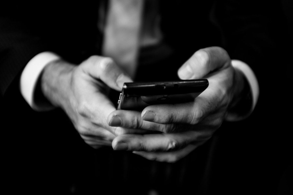 A finger touching the screen of a smartphone.