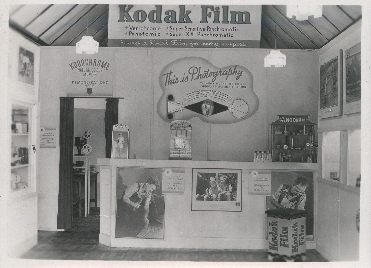 An independent shop owner standing behind a counter beside a card terminal.